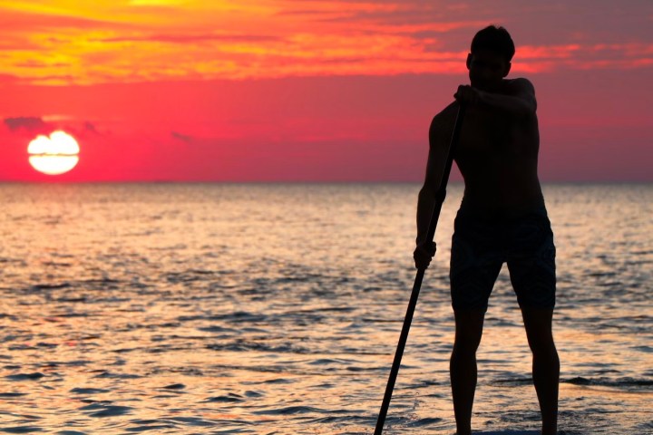 a man standing next to a body of water